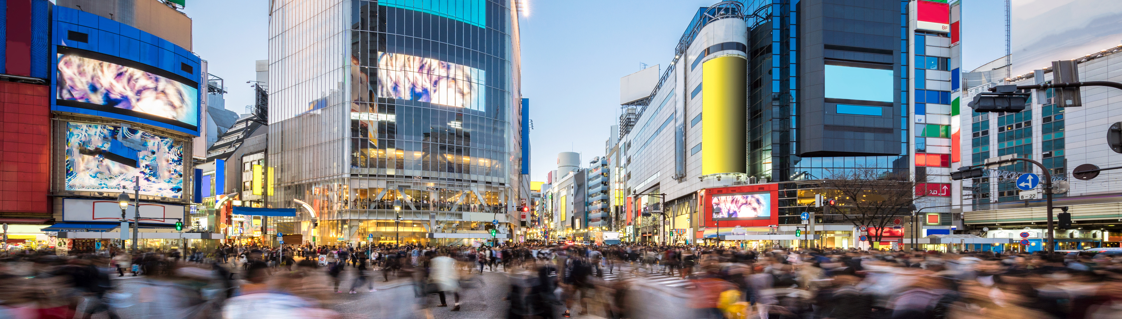 Drukke oversteekplaats van voetgangers in Tokio met kleurrijke gebouwen op de achtergrond