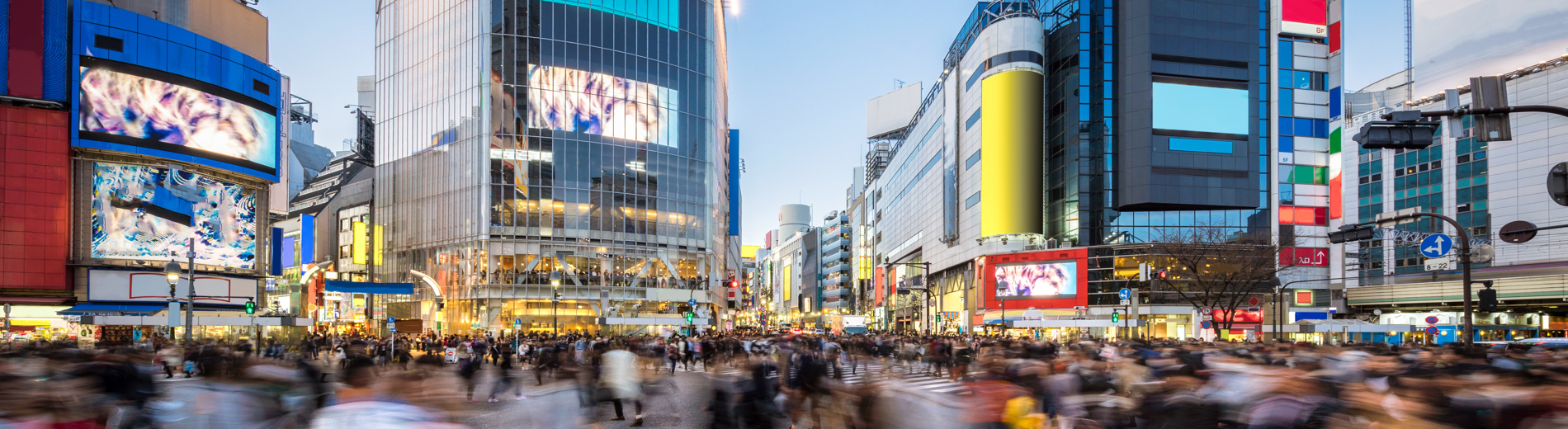 Drukke oversteekplaats van voetgangers in Tokio met kleurrijke gebouwen op de achtergrond